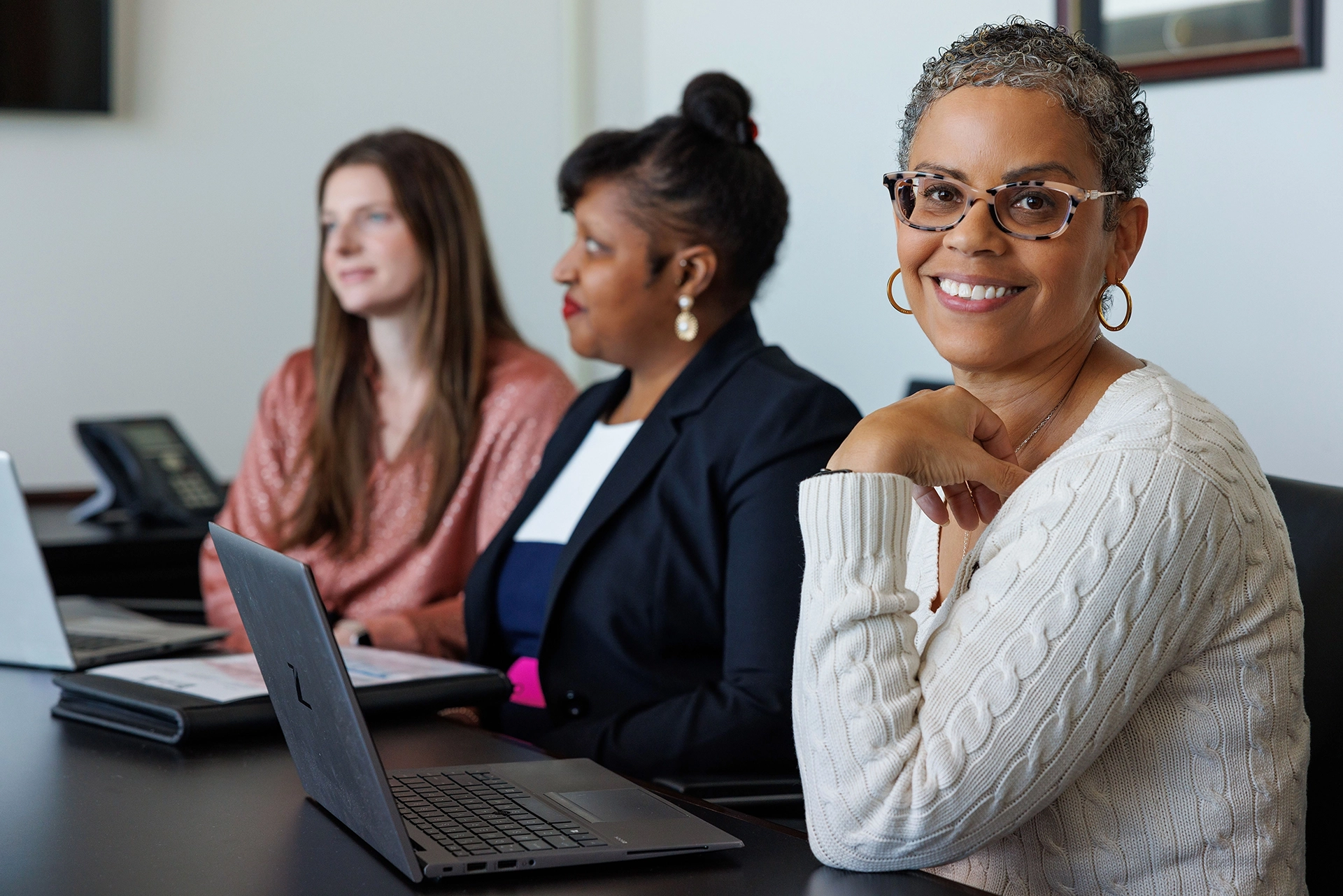 Summit employee smiles while working on a laptop.