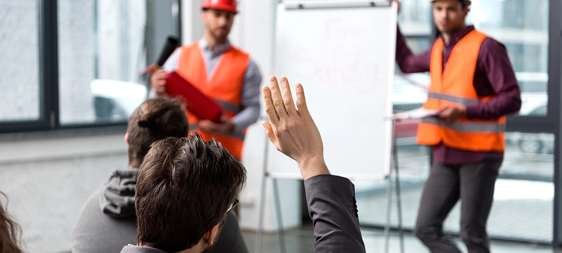 Employee raising their hand during a safety presentation.